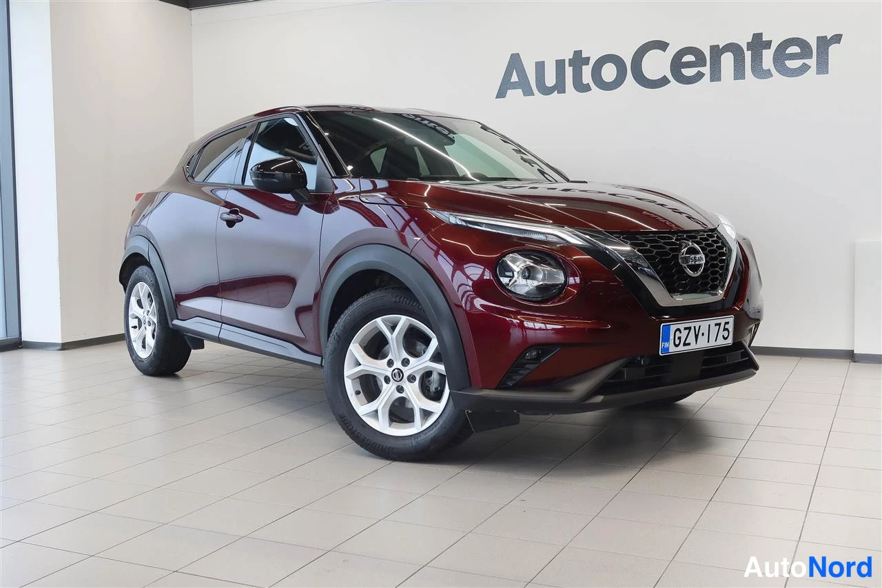Etuviisto, nokka oikealle: Punainen Nissan Juke kuvattu etukulmasta sisätiloissa, rekisterikilpi.