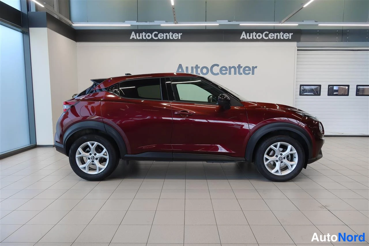 Sivulta: Punaisen Nissan Juken sivuprofiili sisätiloissa.