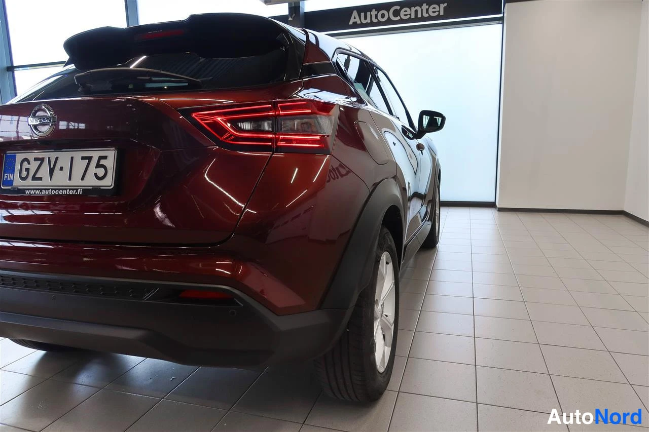 Takaviisto: Tummanpunaisen Nissan Juken takakulma lähikuvassa, rekisterikilpi.
