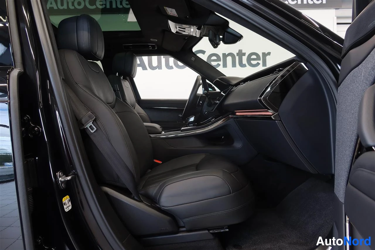 Muu: Auton etupenkillä näkyy musta nahkaverhoilu, turvavyö ja osa kojelaudasta; takana lukee AutoCenter.