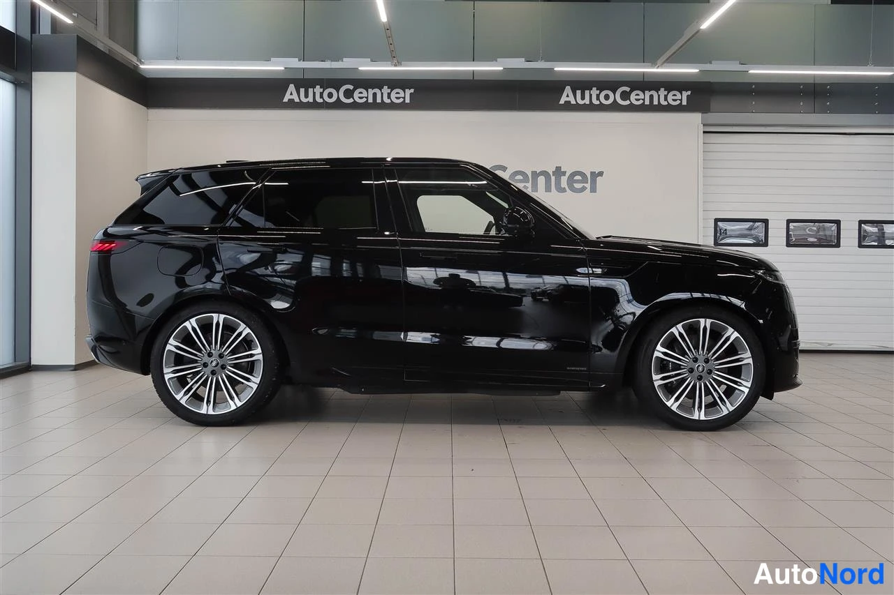 Sivulta: Musta Land Rover Range Rover Sport -henkilöauto sivulta kuvattuna myyntitilassa.