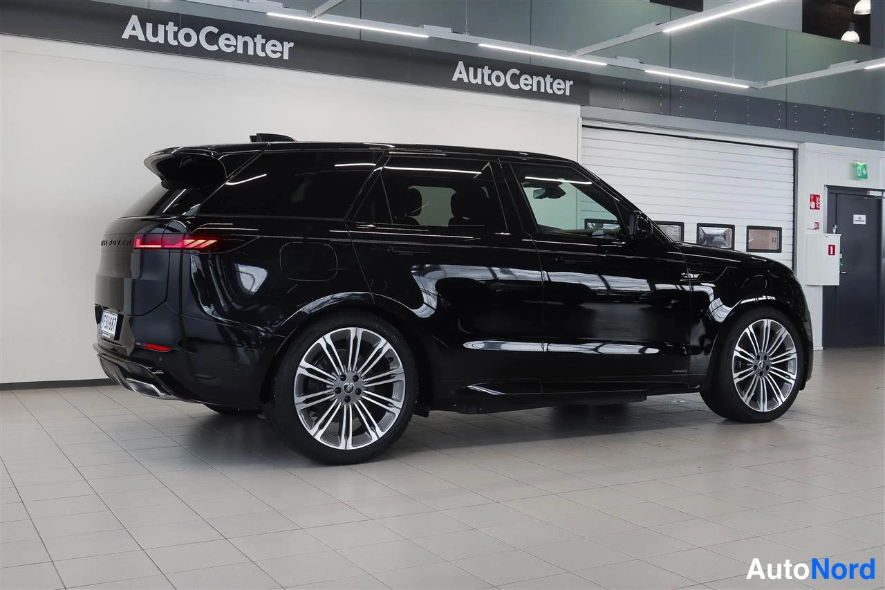 Takaviisto: Mustan SUVin takaosa ja vasen sivu näkyvät AutoCenterin tiloissa, monihaaravanteet taustapeili sukassa.