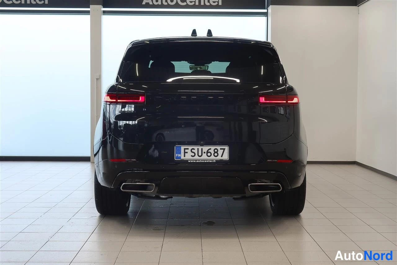 Takaa: Mustan SUVin takaosa suoraan takaa: punaiset takavalot, rekisterikilpi, FIN-merkintä ja www.autocenter.fi -teksti, kaksi pakoputkea.
