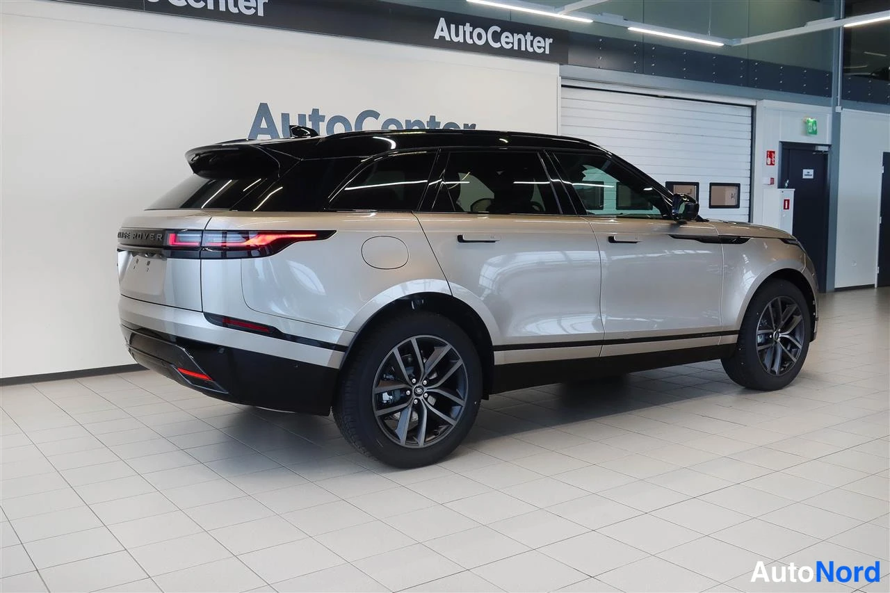 Takaviisto: Beige Range Rover Velar takaviistosta automaalissa, musta katto ja takavalojen valot päällä.