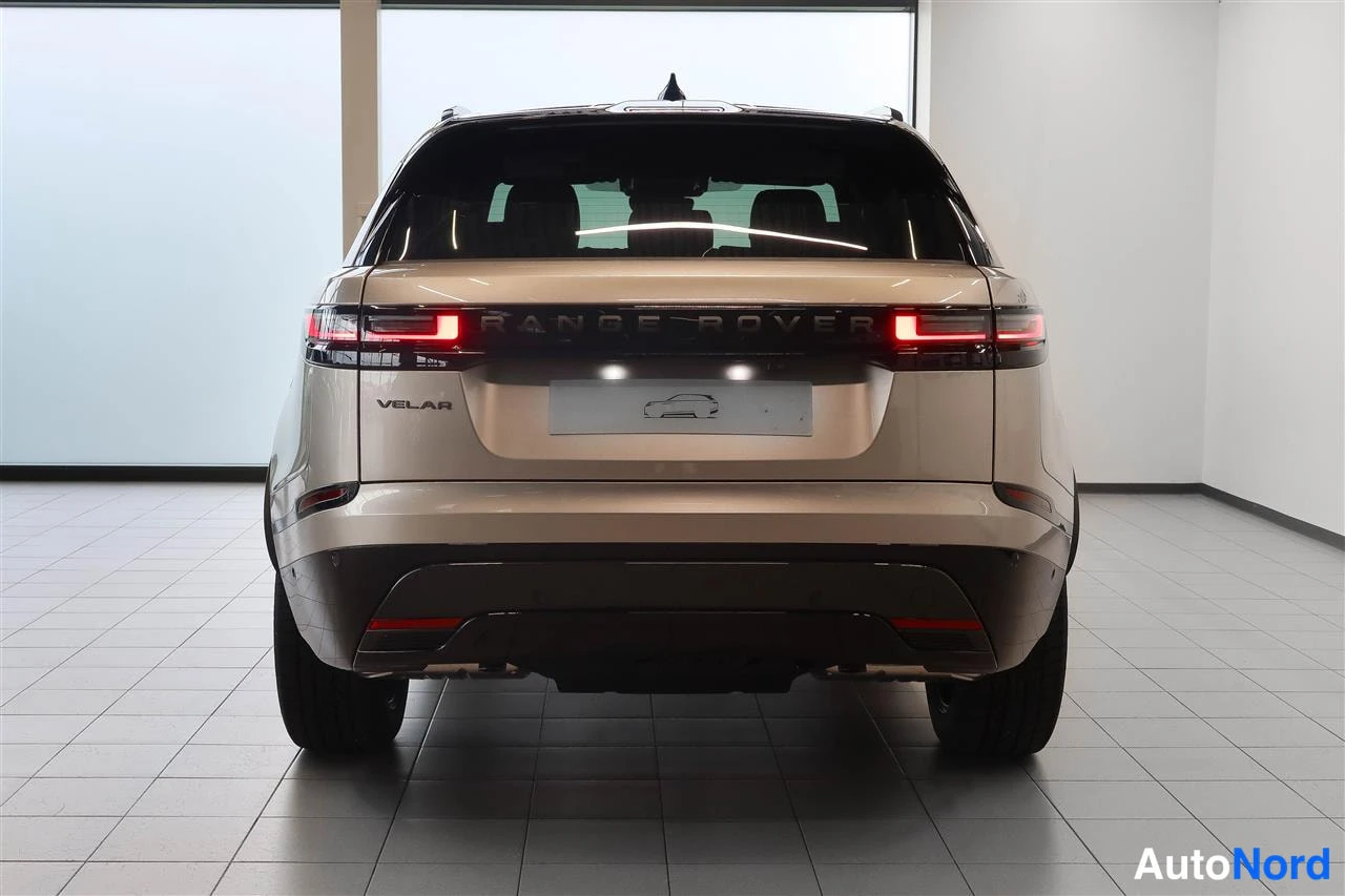 Takaa: Beige Range Rover Velar suoraan takaa; takaluukissa RANGE ROVER- ja VELAR-tekstit.