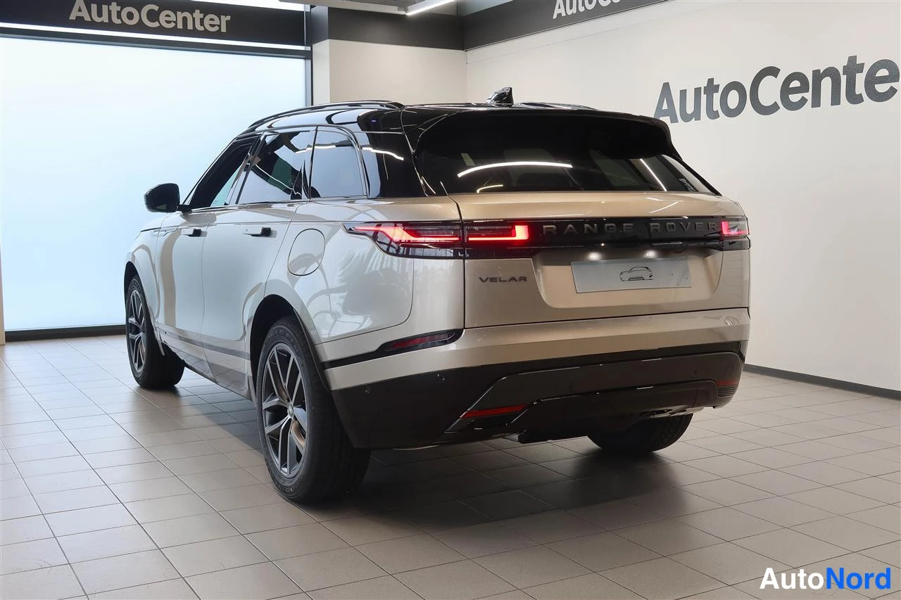 Takaviisto: Beige Range Rover Velar takaviistosta oikealta; VELAR-teksti takaluukussa ja mustat vanteet.