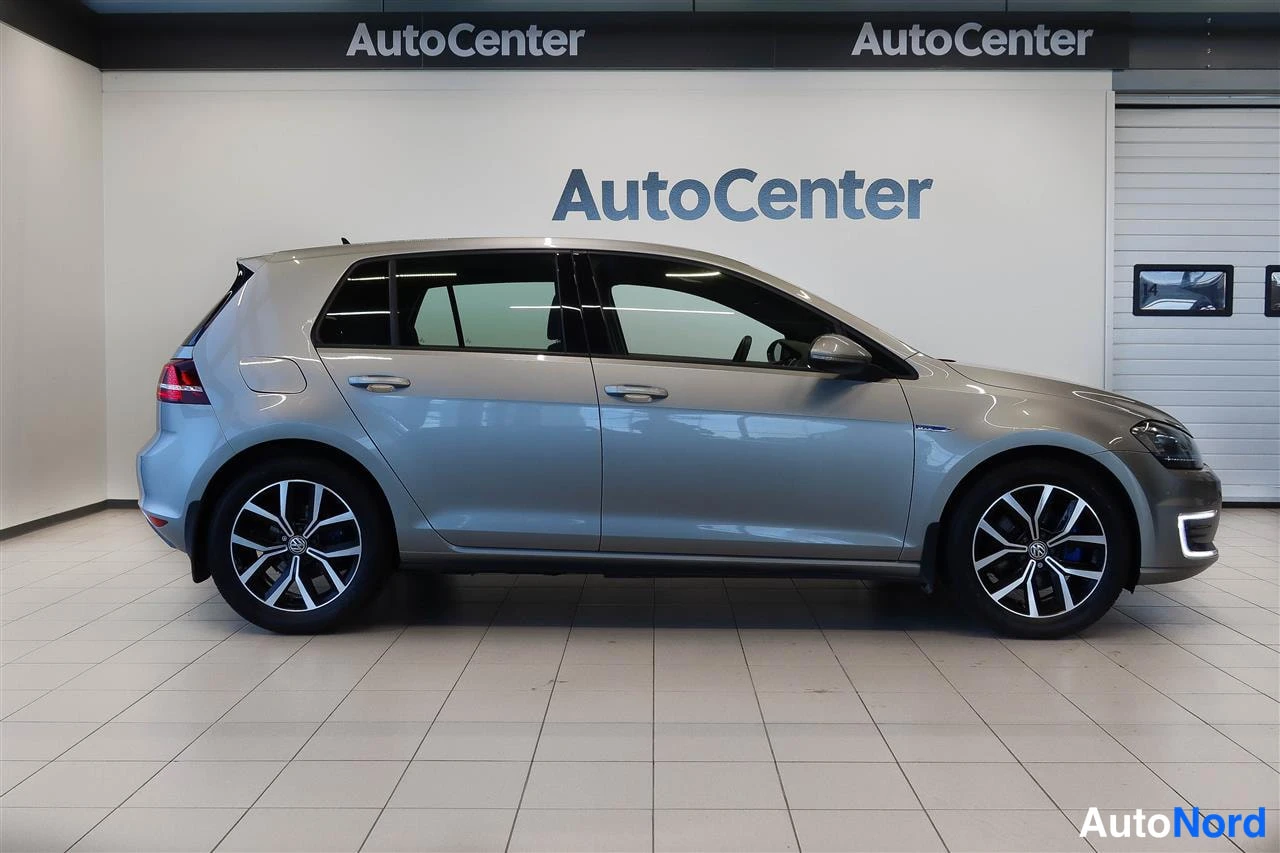 Sivulta: Volkswagen Golf sivulta oikealta, hopeanharmaa korinpinta, viisiovinen viistoperä.