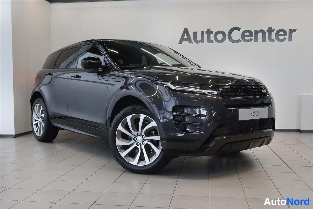 Etuviisto, nokka oikealle: Mustanharmaa Range Rover Evoque esillä autonhallissa, etukulmakuva oikealta.