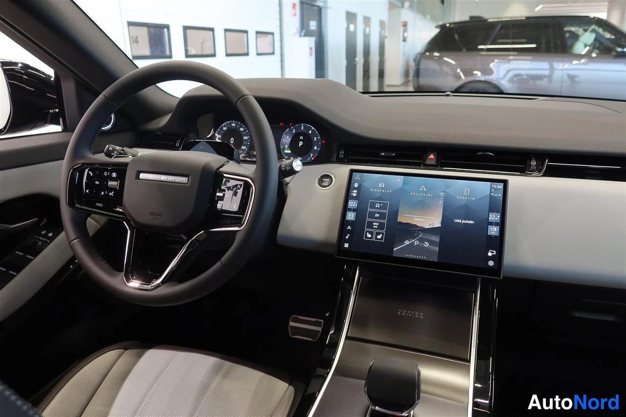 Yksityiskohta: Ohjaamo vasemmalta kuvattuna: Land Rover -rattoni, digitaalinen mittaristo ja keskitönnyn suuri kosketusn€yttö, vaaleat istuimet.