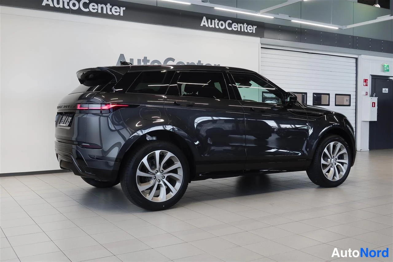 Takaviisto: Tummanharmaan Land Rover Range Rover Evoquen takakulma näkyvissä autonnäyttelyhallissa.