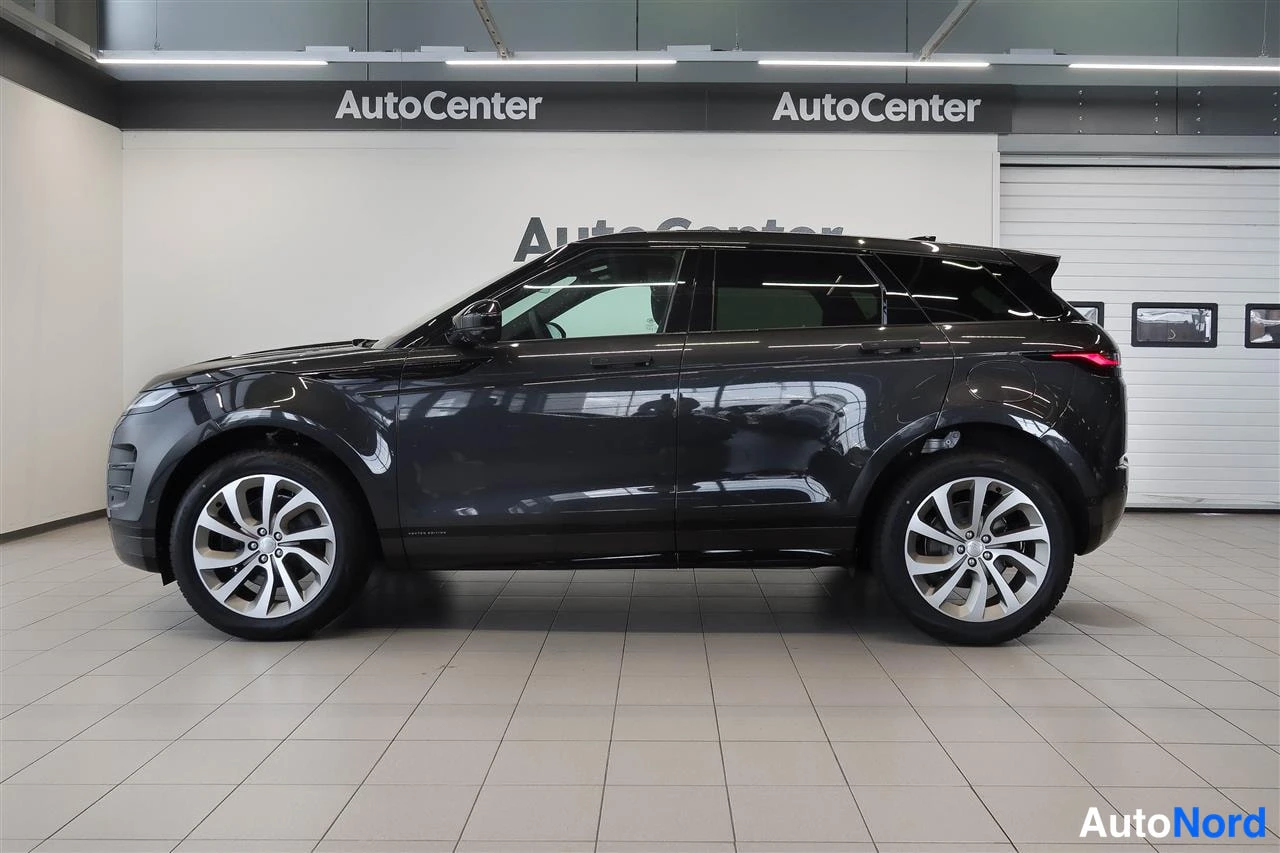 Takaviisto: Tummanharmaan Land Rover Range Rover Evoquen sivukulma, takavalot ja kylki näkyvät autonäyttelyhallissa.
