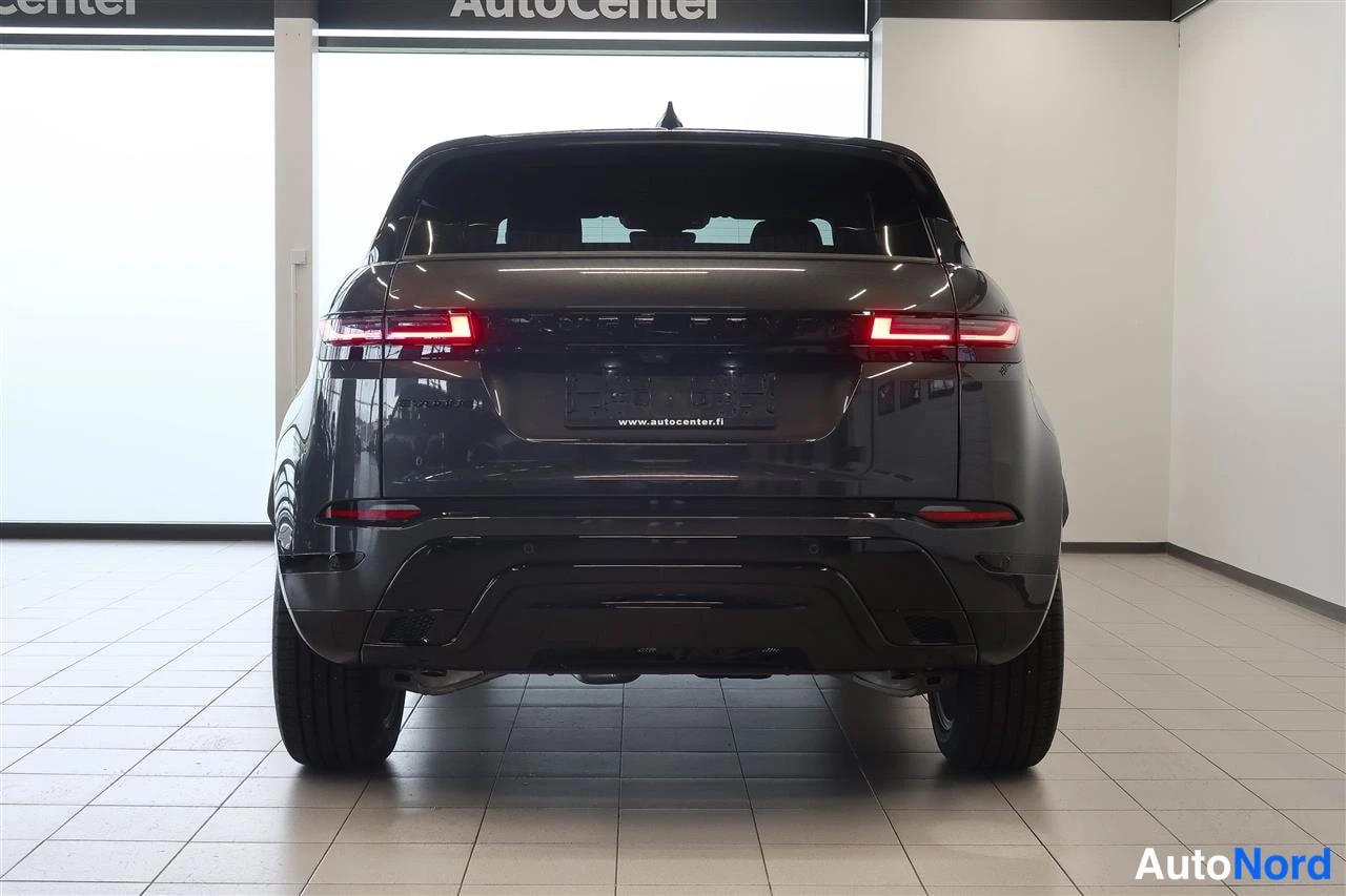 Takaa: Auton takaosa: tummanharmaa Range Rover Evoque -tyylinen katumaasturi takaa kuvattuna, LED-takavalot ja takapuskuri näkyvissä autotallin lattiassa.