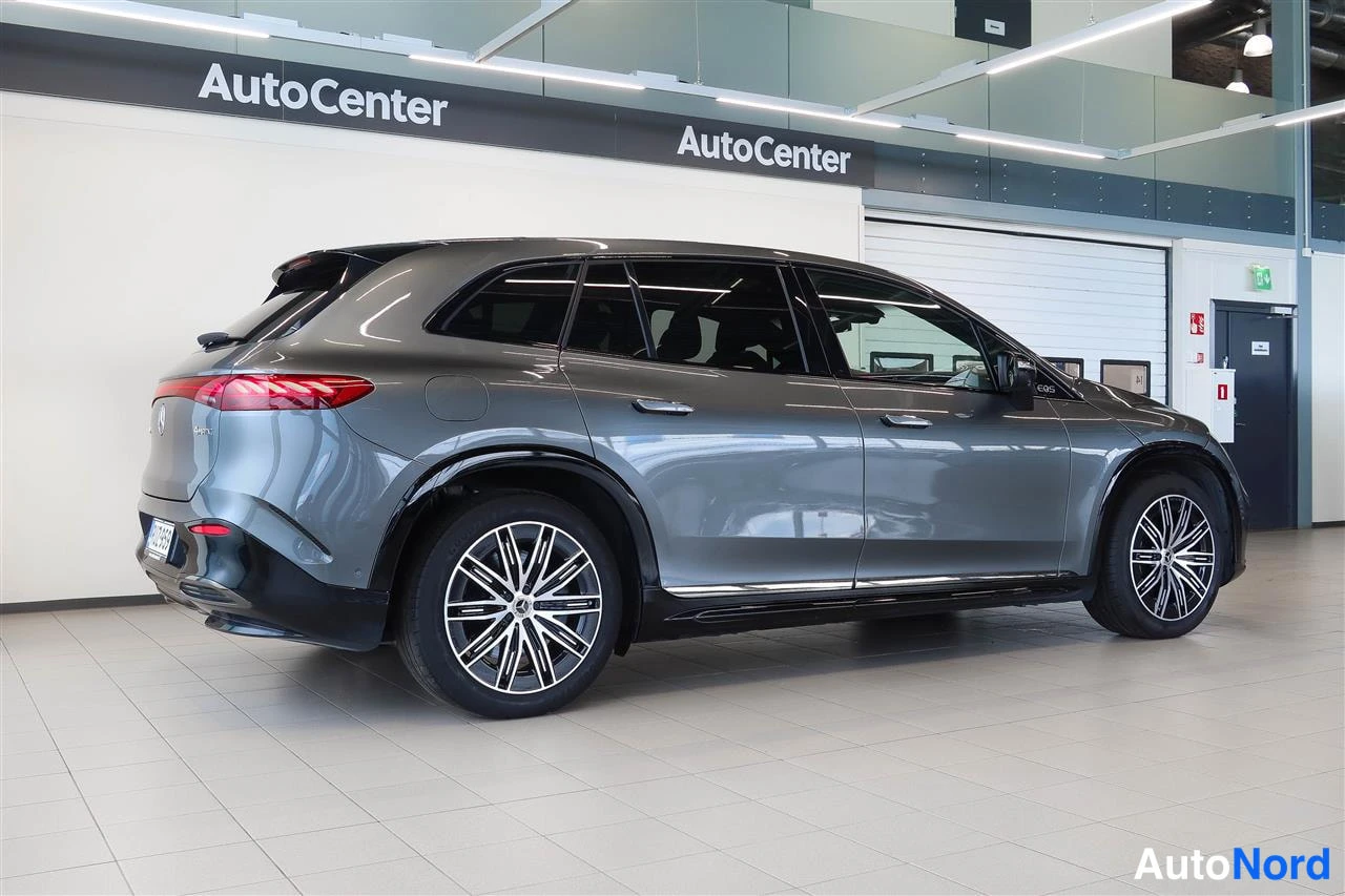 Takaviisto: Auton takakolmasosan kuva: harmaan Mercedes-Benz EQS SUV:n perä ja oikea sivu näkyvissä showroomissa.