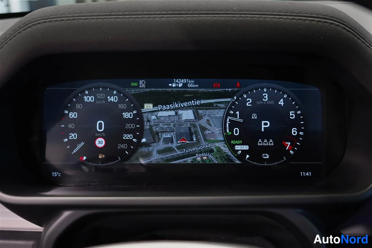 Yksityiskohta: Digitaalinen kuljettajan näyttö: nopeusmittari 0 km/h, matkamittari 142491 km, vaihde P ja navigointikartta Paasikiventie-kadulla.
