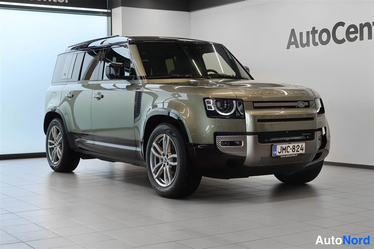 Etuviisto, nokka oikealle: Land Rover Defender oliivinvihreä etukulmasta oikealta, myymälätilassa
