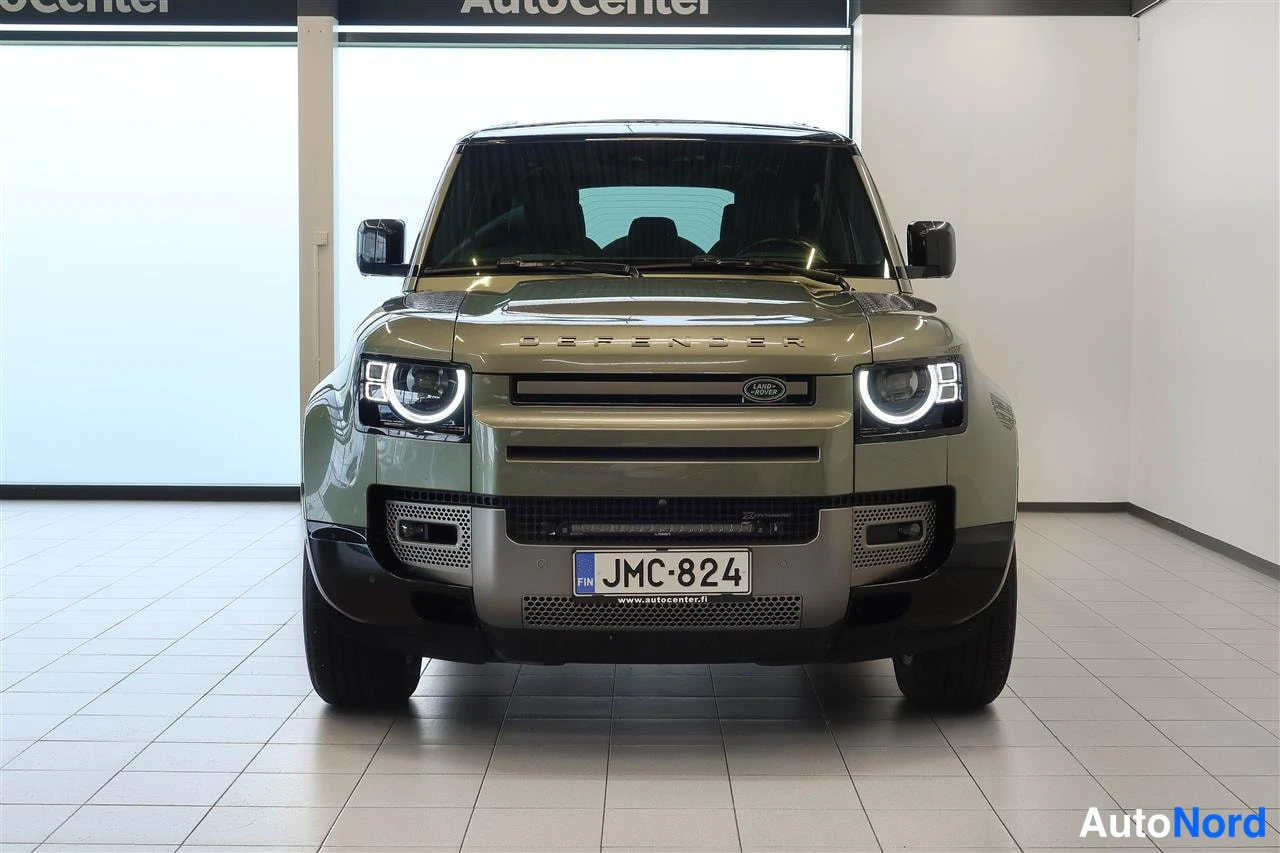 Edestä: Land Rover Defender oliivinvihreä suoraan edestä, keula ja rekisterikilpi näkyvissä