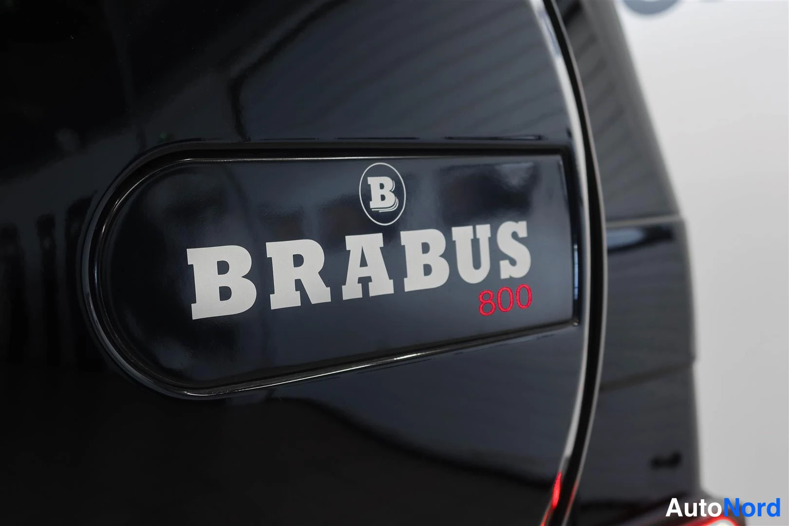 Yksityiskohta: Lähikuva varapyörän kannen BRABUS 800 -tunnuksesta mustalla pinnalla.