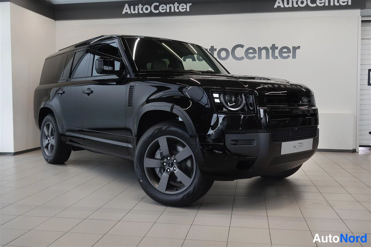 Etuviisto, nokka oikealle: Musta Land Rover Defender näkyvissä Autocenter-tilassa, keulan ja vasemman kyljen kolmannelta neljännekseltä kuvattuna.