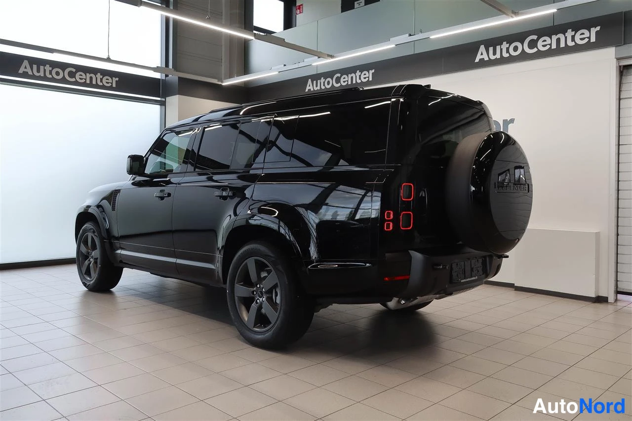 Takaviisto: Land Rover Defenderin takaosa kolmannelta kuvakulmalta; musta koripaneeli, pystysuorat takavalot ja varapyörä erottuvat nokan ollessa vasemmalla.