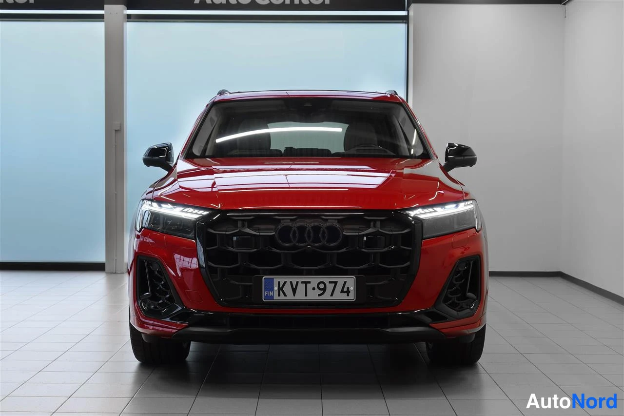 Edestä: Punaisen Audin etunäkymä suoraan edestä, musta säleikkö ja Audi-merkit, rekisterikilpi.