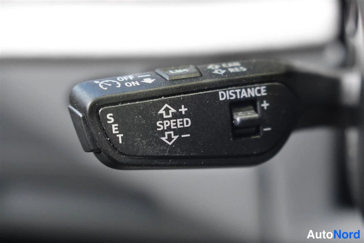 Yksityiskohta: Lähikuva ohjaustangon kytkimestä, jossa näkyvät merkit OFF/ON, SET, SPEED ja DISTANCE -säädin, mikä osoittaa mukautuvan vakionopeudensäädön.