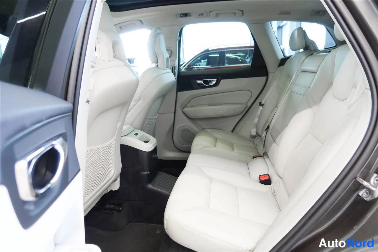 Yksityiskohta: Takaistuimet ja matkustamon takaosa, vaaleat istuimet ja keskinen armrest.
