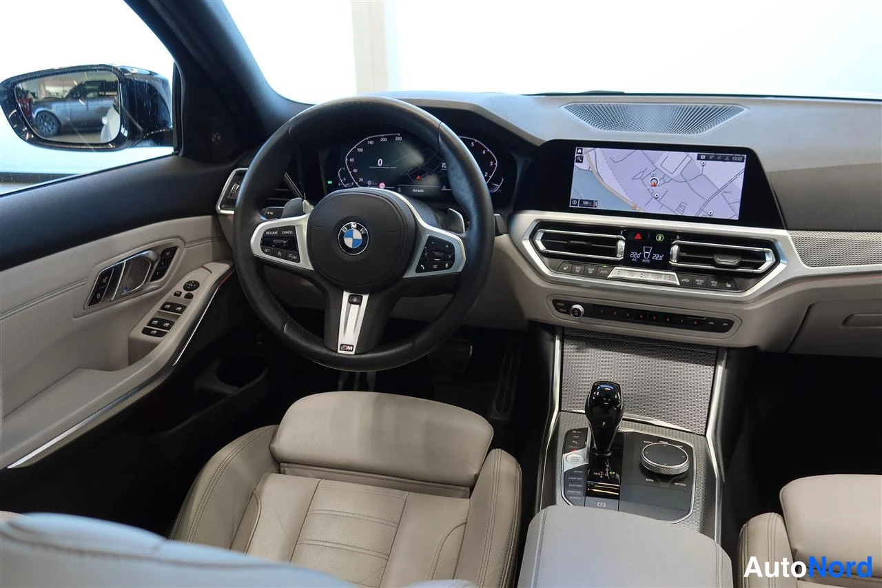 Muu: Ohjaamosta näkyy BMW-ohjauspyörä, digitaalinen mittaristo ja suuri karttaan avautuva keskinäyttö.