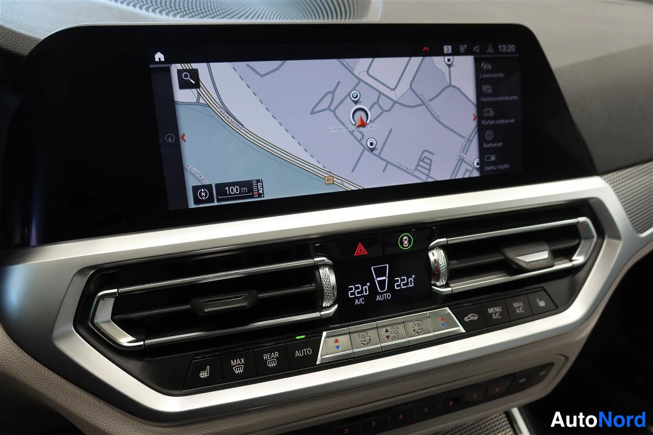 Yksityiskohta: Kohtakuva auton kojelaudasta: kartta näkyvillä otsikkonäytössä ja kaksitoistavyöhykeinen automaatti-ilmastointipaneeli, jossa näkyy 22,0 asti molemmin puolin.