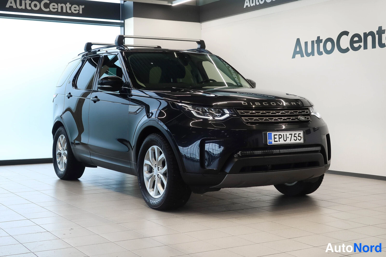 Etuviisto, nokka oikealle: Land Rover Discovery, musta, kolmivartin etukuva oikealta, katolla telineet, rekisteri.
