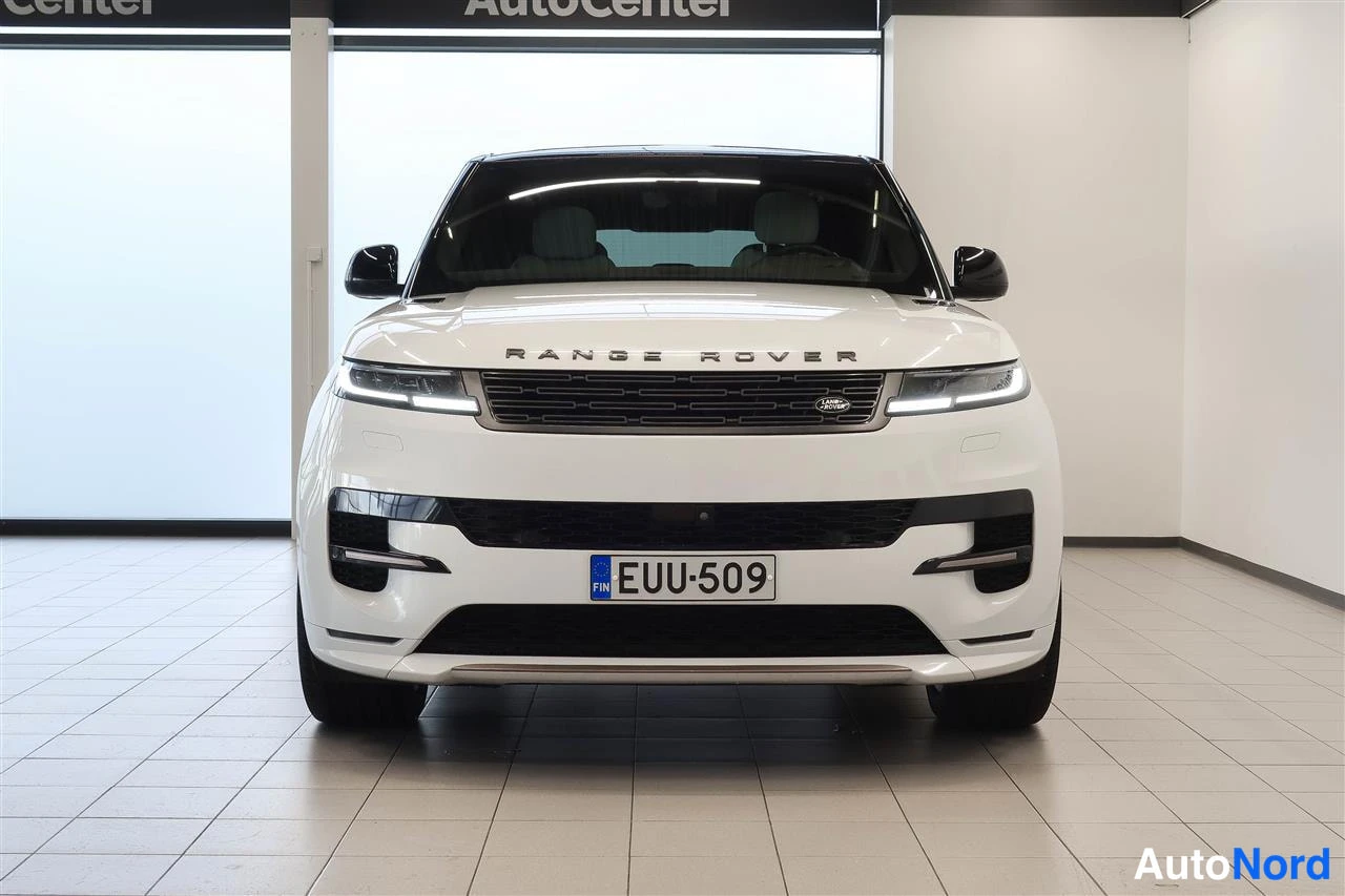 Edestä: Valkoisen Land Rover Range Rover Sportin etunäkymä suoraan edestä; LED-ajovalot, musta etusäleikkö ja rekisterikilpi.