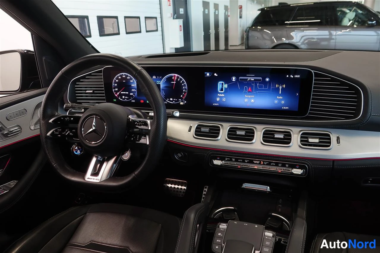 Edestä: Detail-kuva mustasta Mercedes-Benz-auton kojelaudasta: mittaristo ja keskistiksi.