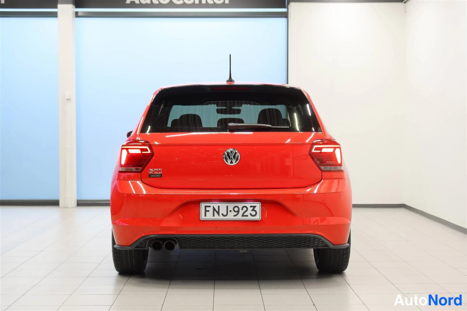 Takaa: Punaisen Volkswagen Polon takaosa suoraan takaa, rekisteritunnus.