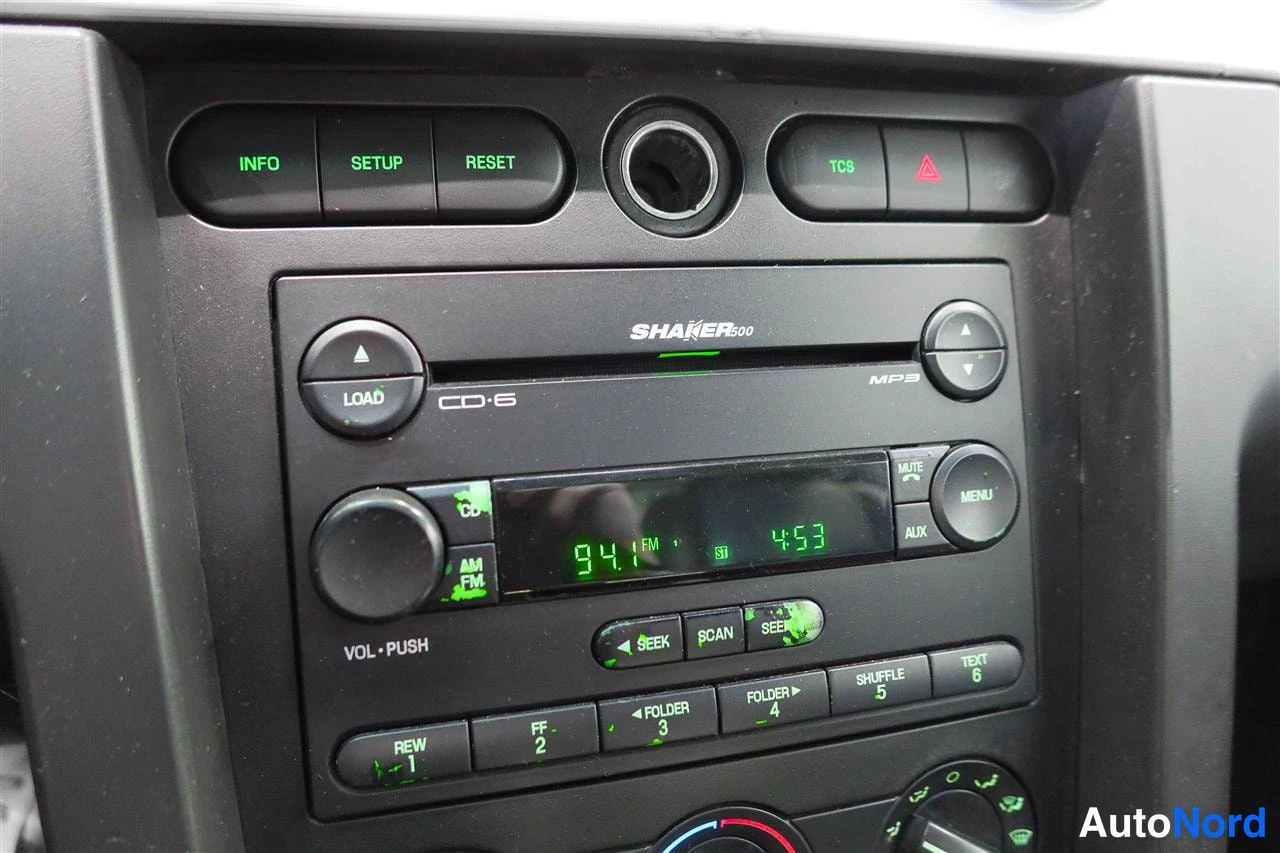 Yksityiskohta: Auton kojelaudan radio: Shaker 500 CD-6-soitin, näytössä 94.7 FM, ympärillä INFO-, SETUP-, RESET- ja TCS-painikkeet.