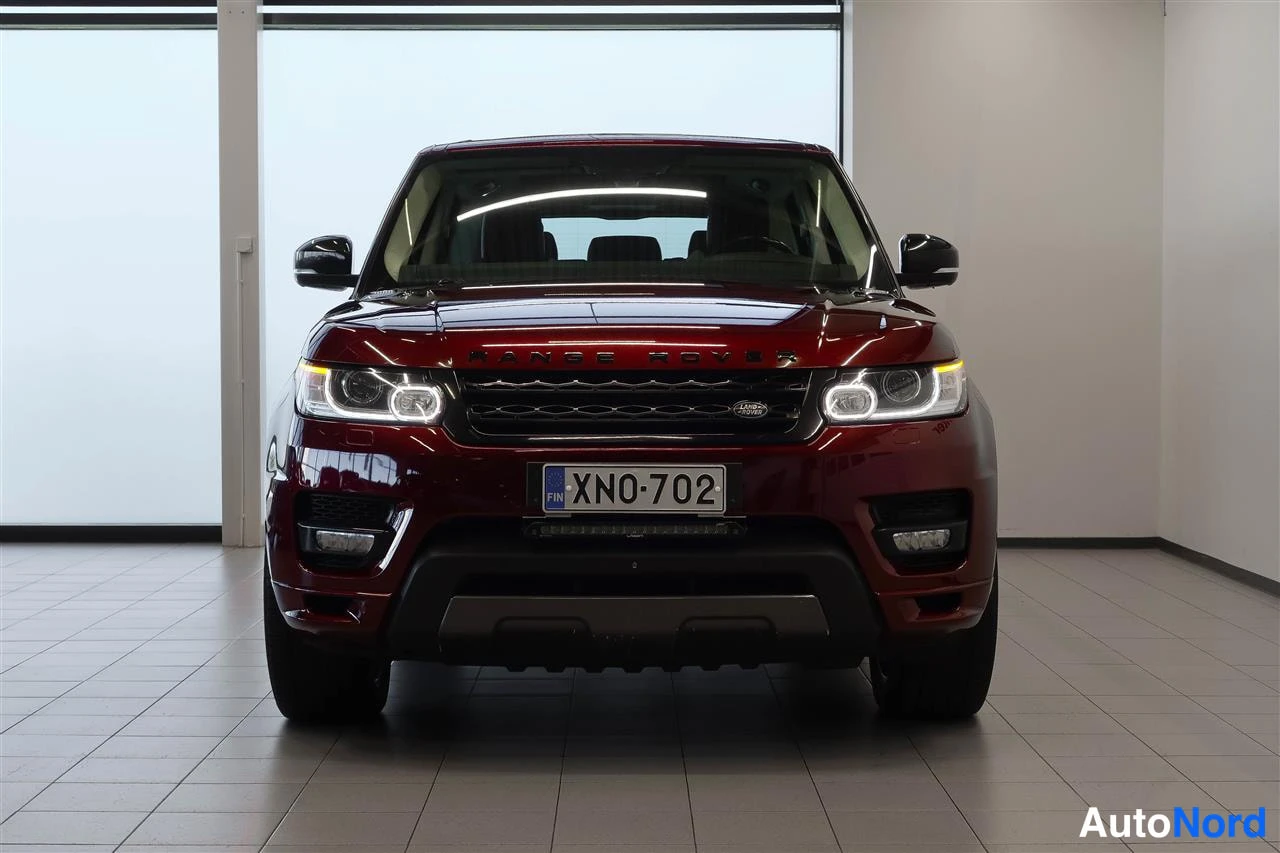 Edestä: Punainen Land Rover Range Rover Sport suoraan edestä, rekisterikilpi.