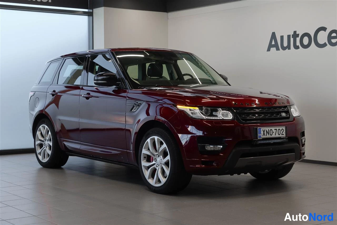 Etuviisto, nokka oikealle: Punainen Land Rover Range Rover Sport etukulmasta oikealta sisätiloissa, rekisterikilpi.