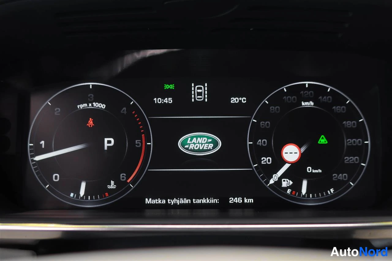 Yksityiskohta: Kojetaulun näyttö: nopeusmittari, kierroslukumittari, Land Rover -logo, teksti 'Matka tyhjään tankkiin: 246 km', kello 10:45 ja lämpötila 20 °C.
