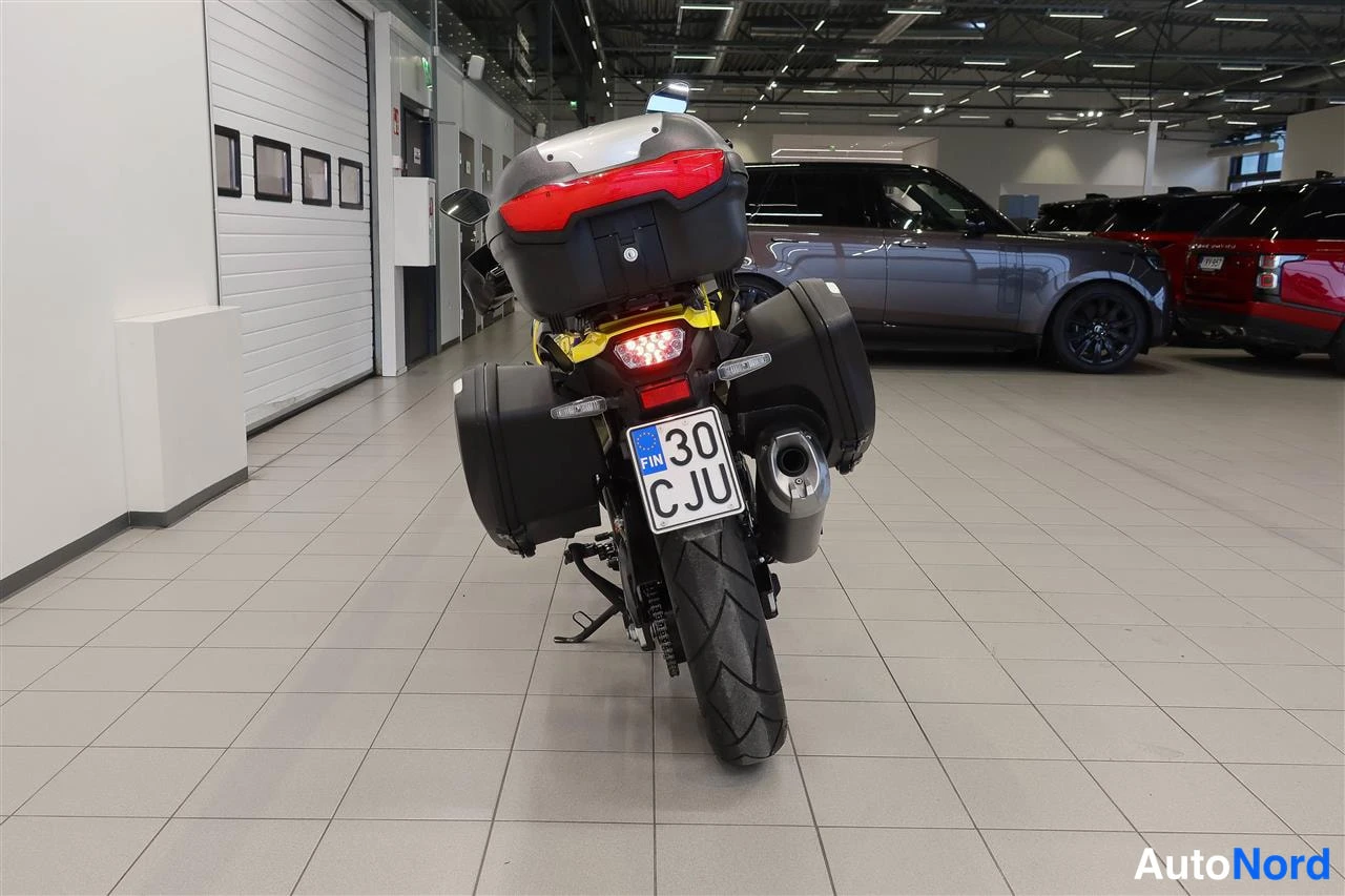 Takaa: Suzuki V-Strom 1050 -moottoripyörä sisätilassa suoraan takaa, jarruvalot päällä ja rekisterikilpi FIN 30 CJU.