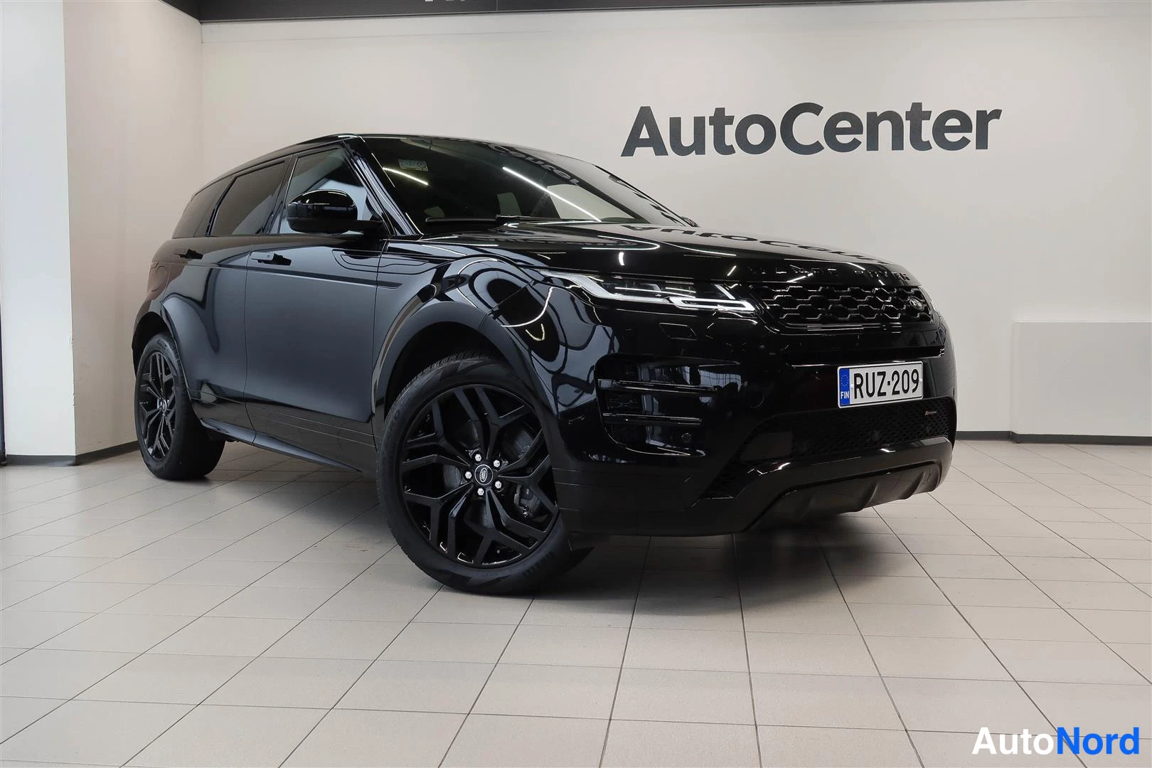 Etuviisto, nokka oikealle: Musta Land Rover Range Rover Evoque etukolmessenasta sisätiloissa, rekisteritunnus.
