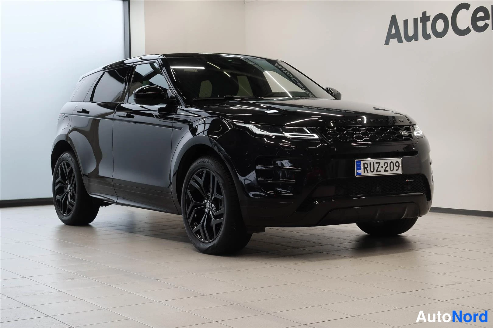 Etuviisto, nokka oikealle: Musta Land Rover Range Rover Evoque etukolmessenasta sisätiloissa, rekisteritunnus.