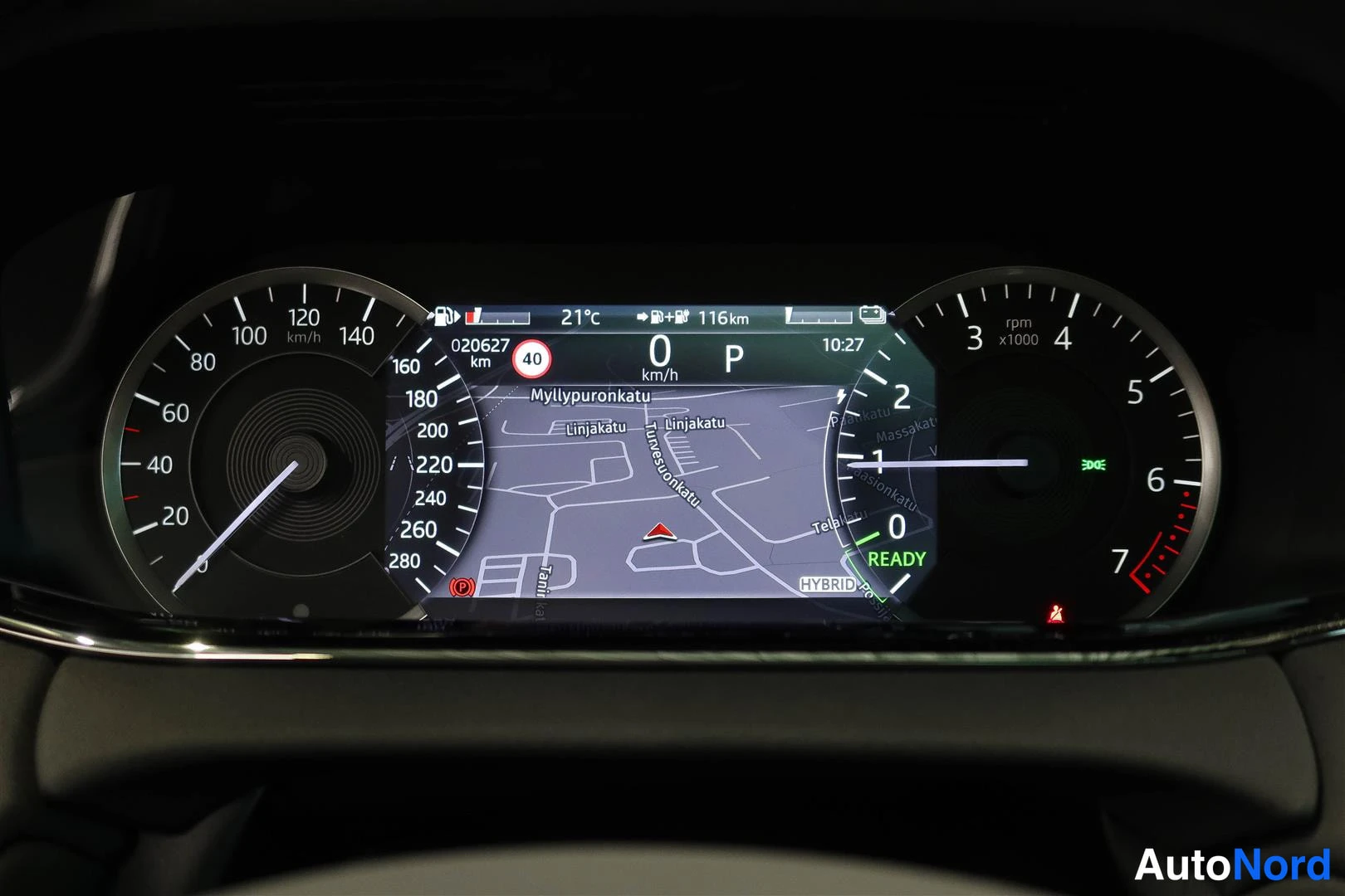 Yksityiskohta: Mittaristön näyttö näyttää hybridin READY-tilan, 0 km/h, P-vaihteen ja navigointikartan.