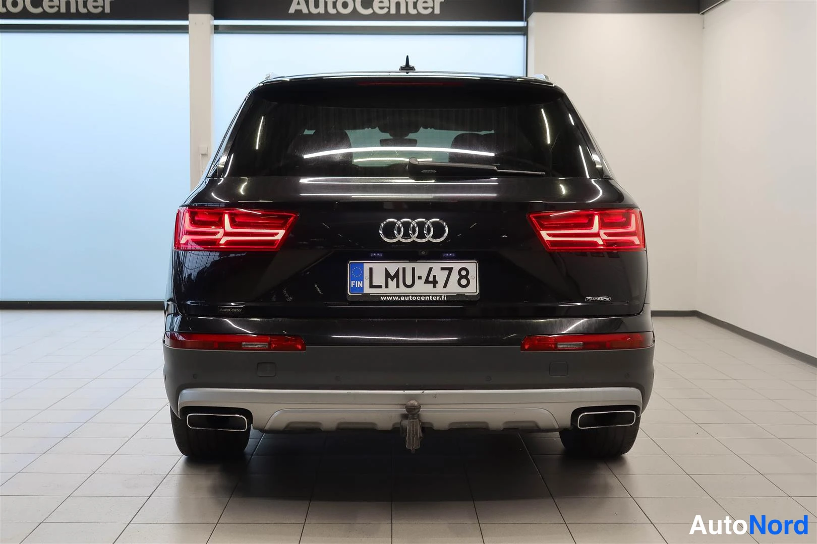 Takaa: Mustan AUDI Q7:n takanäkymä, suomi rekisterikilpi, neljä pakoputkea ja kiinnityskoukku takapuskurissa.