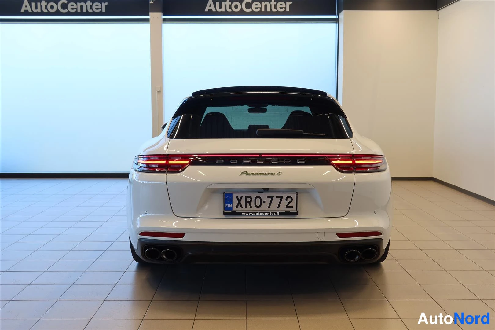 Takaa: Auton takanäky: valkoisen Porsche Panamera Sport Turismo -farmarin perä, tl:stä, punaiset takavalot ja neljä pakoputkea.