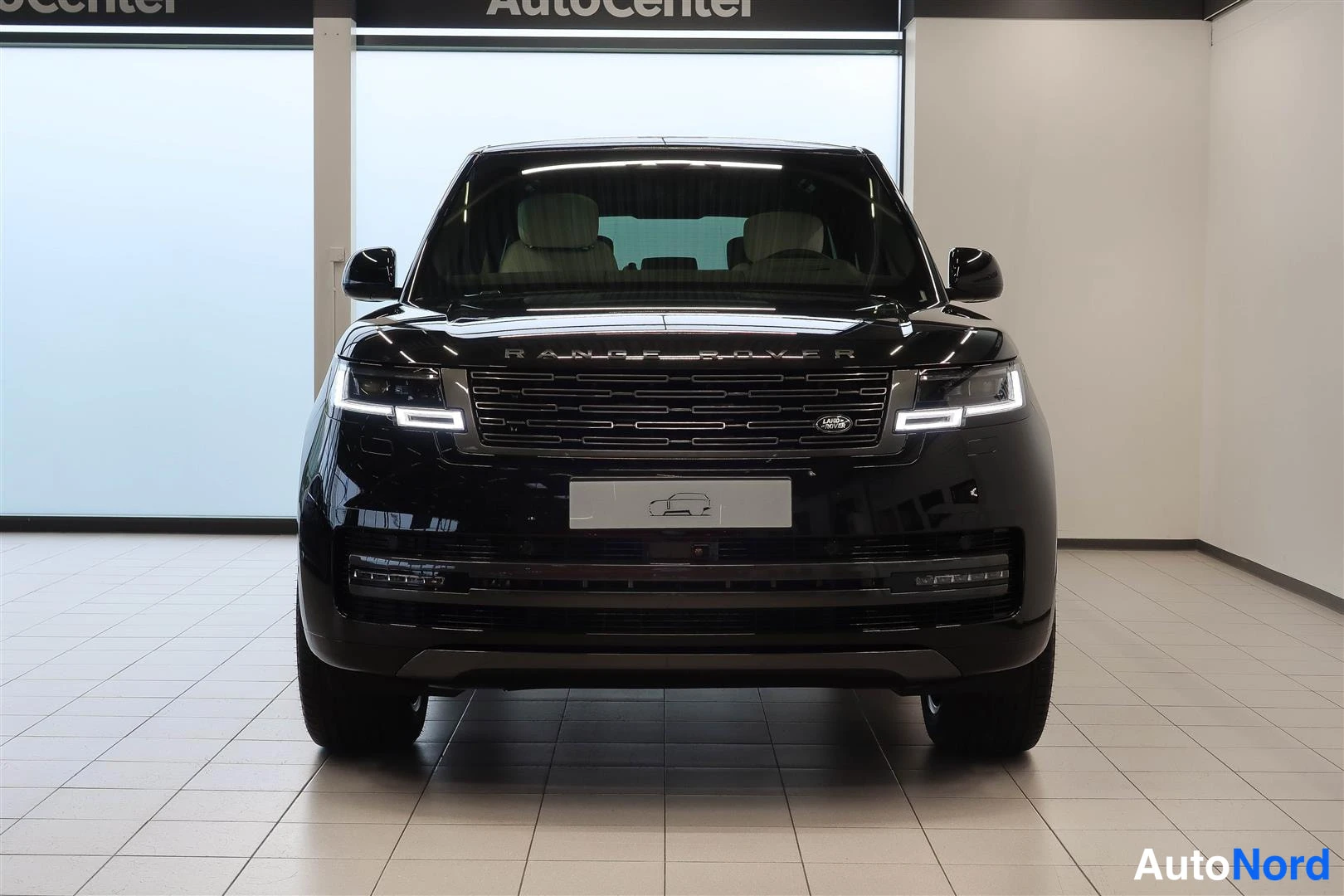 Edestä: Musta Range Rover suoraan edestä kuvattuna, etusäleikkö, ajovalot ja Range Rover -teksti konepellissä näkyvissä.