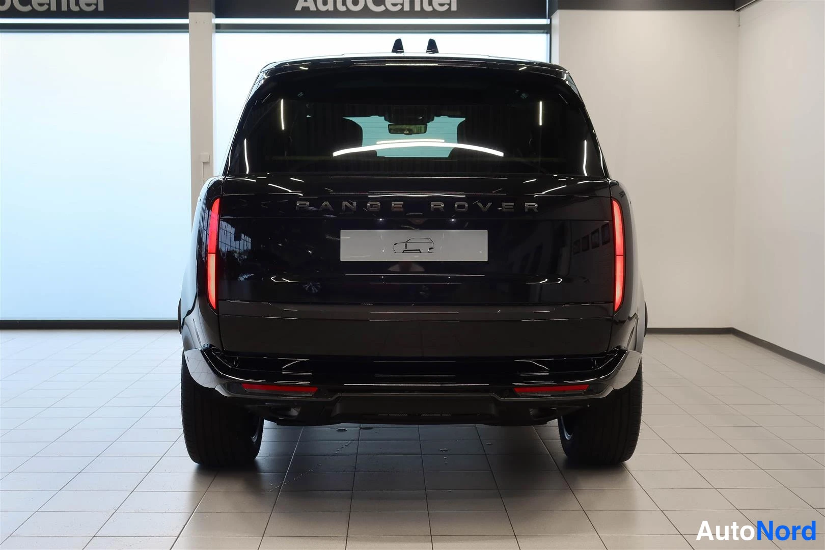 Takaa: Mustan auton takaosa suoraan takaa kuvattuna; takalasin kohdalla RANGE ROVER -teksti ja ROVER-kirjaimet takapaneelissa.