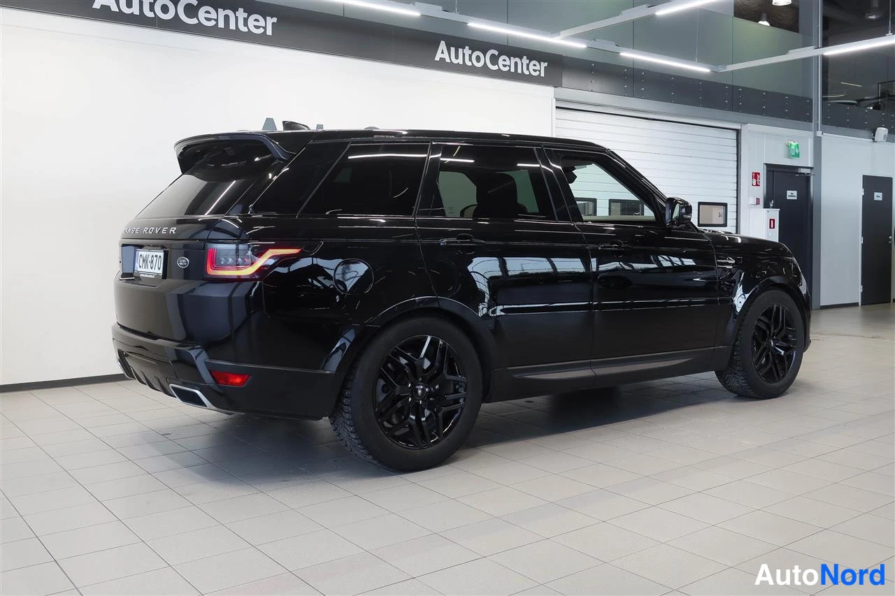 Takaviisto: Land Rover Range Rover Sport -takakulmakuva: musta maastoauto näkyvissä takaa ja sivulta AutoCenterin showroomissa.
