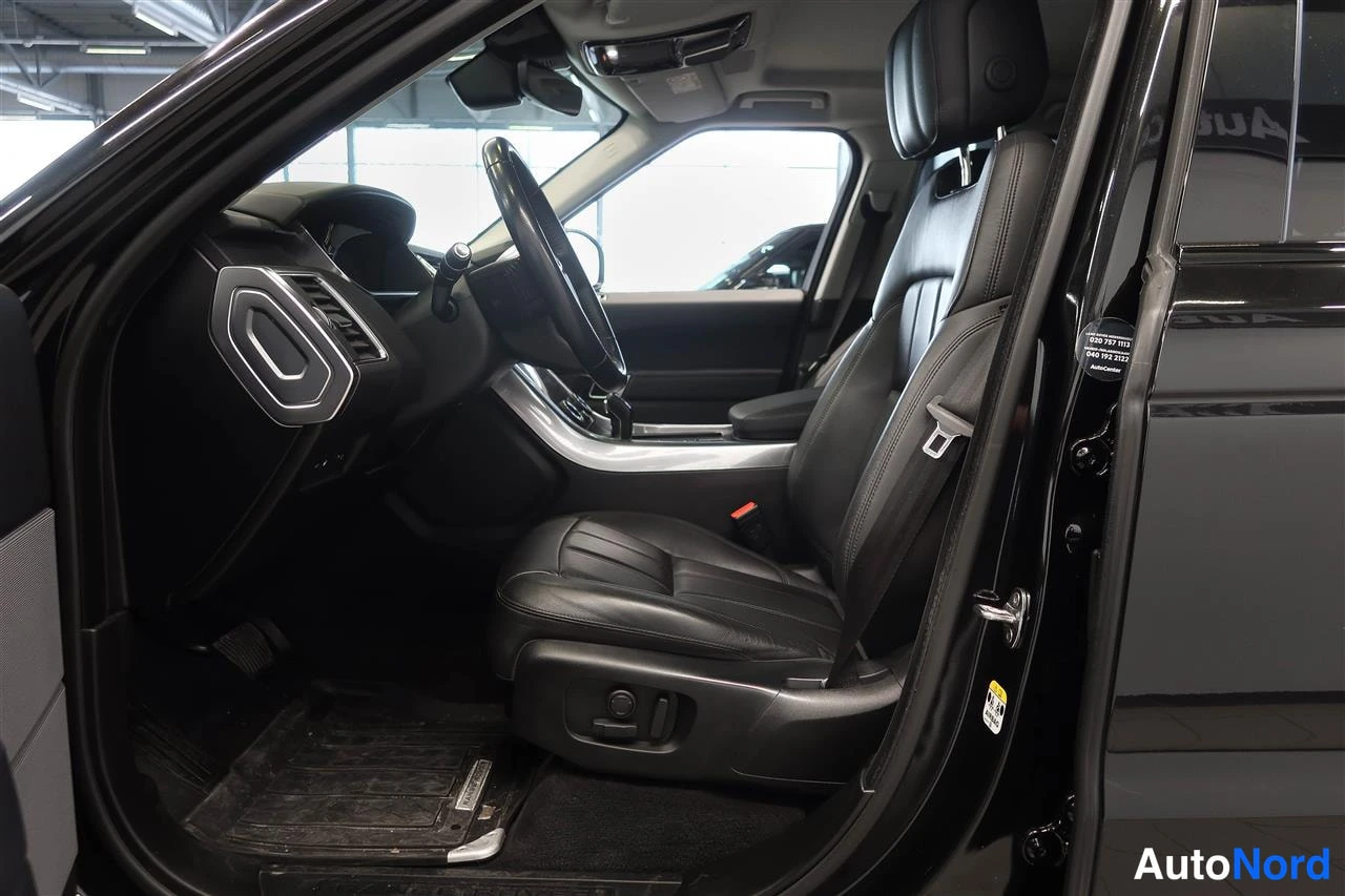 Muu: Range Rover Sportin etusuoja: musta nahkainen kuljettajan istuin, ratissa ja kojelaudan ilmastointisuuttimet näkyvissä ovesta avattuna.
