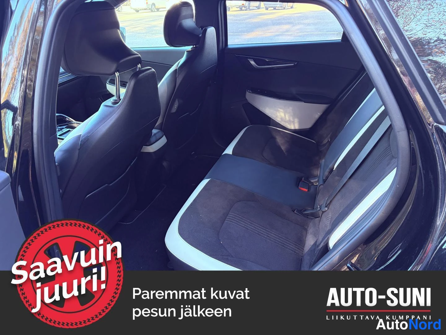 Muu: Mustan Kia EV6:n takapenkki ja selkänoja sisältä. Kuva sisältää mainostekstin 'Saavuin juuri!' ja teksti 'Paremmat kuvat pesun jälkeen'.