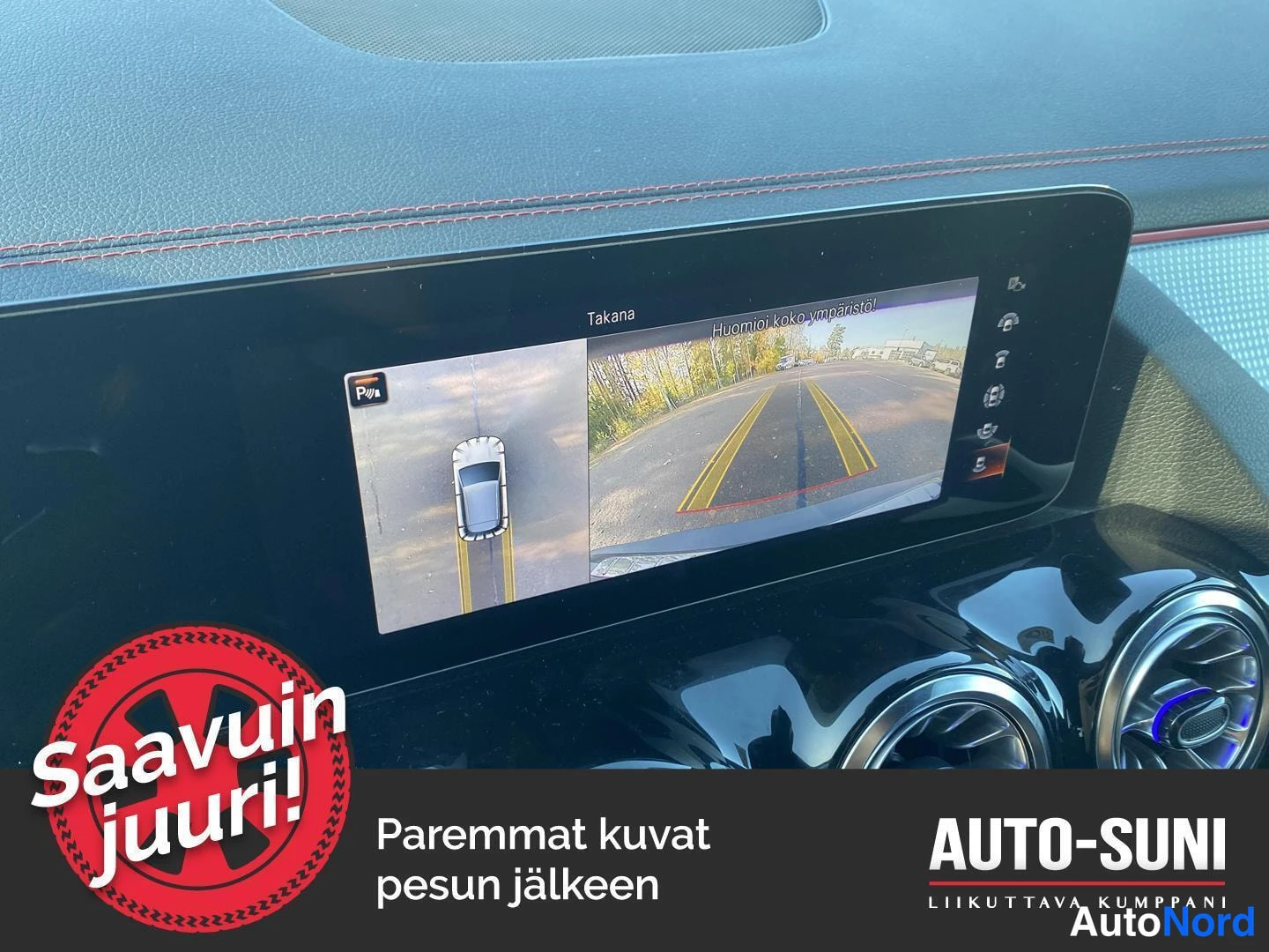 Yksityiskohta: Keskinäyttö näyttää 360-asteen kamerakuvan ('Takana') ja huomiotekstin 'Huomioi koko ympäristö!'.