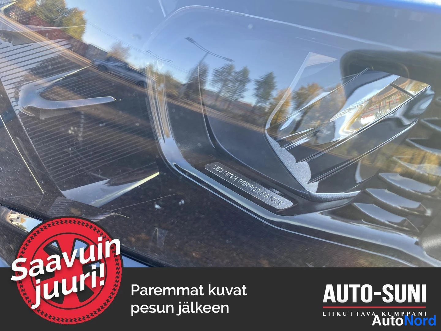 Yksityiskohta: Ajovalaisimen lähikuva, jossa on teksti 'LED HIGH PERFORMANCE', tummaa pintaa ja heijastuksia.