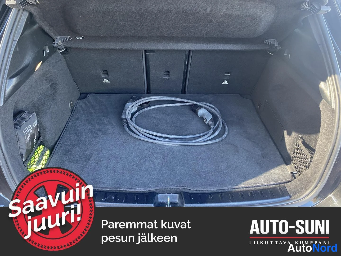 Etuviisto: Tavaratila tyhjillään; lattialla on latauskaapeli kelattuna ja sivulla pelastusliivi.